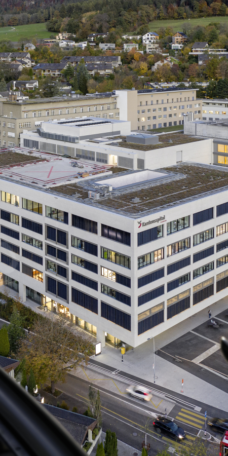 Blick aus einem Helikopter auf das weitläufige Areal des Kantonsspitals Graubünden mit mehreren Gebäuden am Churer Stadtrand.