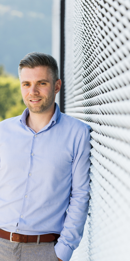 Mitarbeiter der Integra lehnt an die Hauswand an