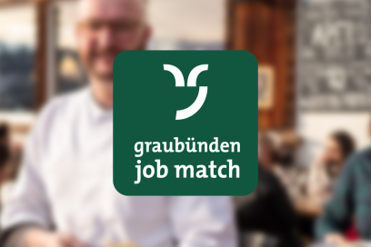Grünes Logo «graubünden job match» mit weissem Graubünden-Signet vor einem unscharfen Hintergrund mit Menschen in einem Innenraum.