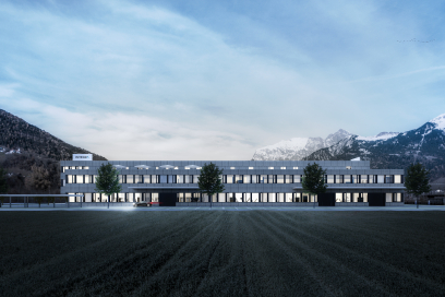 Modernes Firmengebäude von INTEGRA Biosciences mit langen Fensterfronten auf einem weiten Gelände vor einer verschneiten Bündner Bergkulisse.