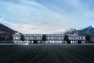 Modernes Firmengebäude von INTEGRA Biosciences mit langen Fensterfronten auf einem weiten Gelände vor einer verschneiten Bündner Bergkulisse.
