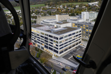 Blick aus einem Helikopter auf das weitläufige Areal des Kantonsspitals Graubünden mit mehreren Gebäuden am Churer Stadtrand.